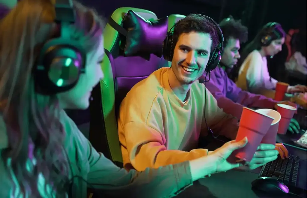 Gaming team tijdens een trainingssessie in een neonverlichte ruimte met headsets en computers